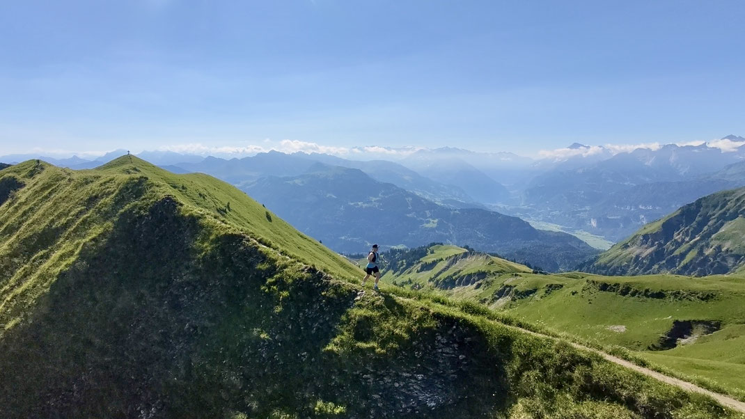 Trailrunner überquert den schmalen Grat zwischen Männli und Höch Gumme, im Hintergrund ist das Haslital ersichtlich
