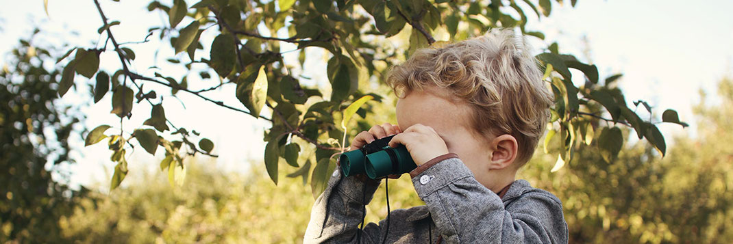 Kind schaut durch Fernglas