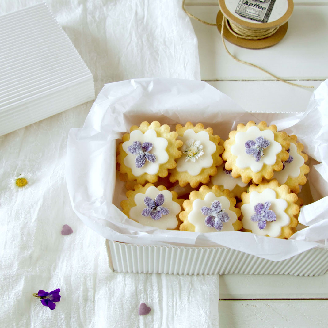 Mürbeteig Kekse mit zuckrigen Veilchen in der selber gemachten Geschenkbox