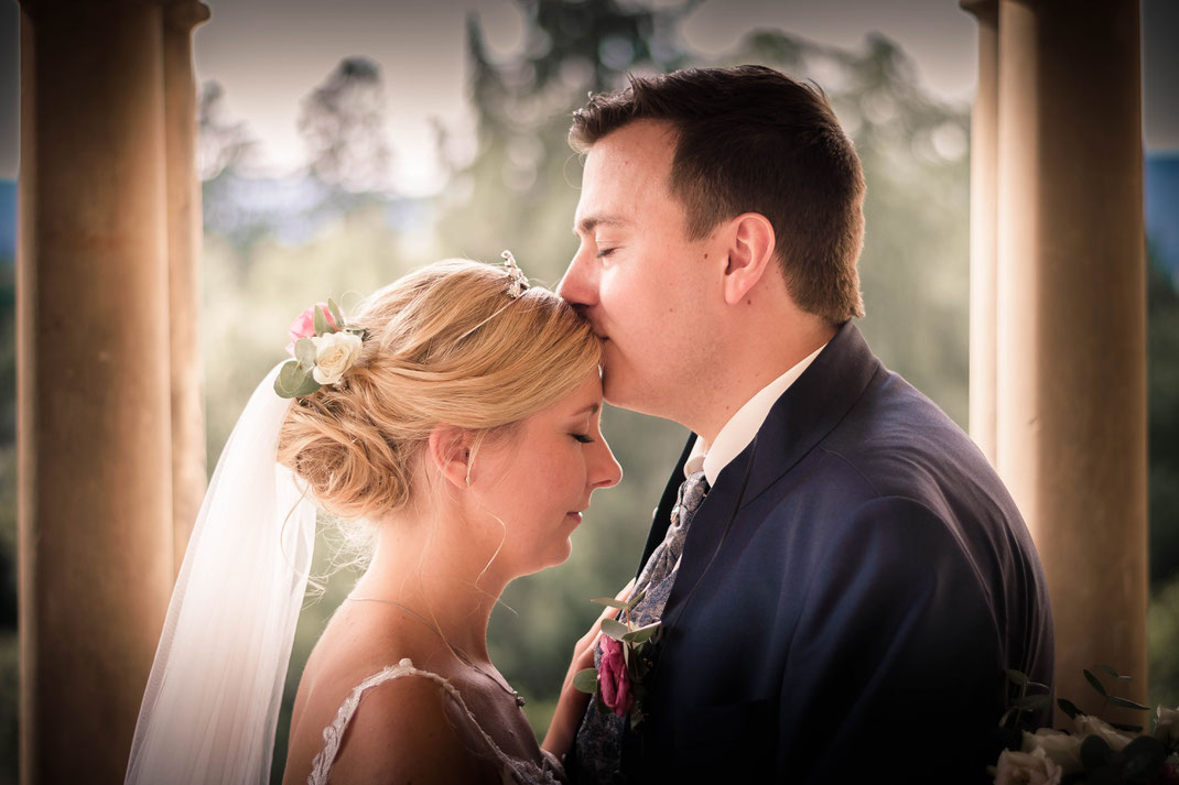 Der Ehemann küsst seine Ehefrau nach der Hochzeit auf die Stirn, in Bad Homburg.