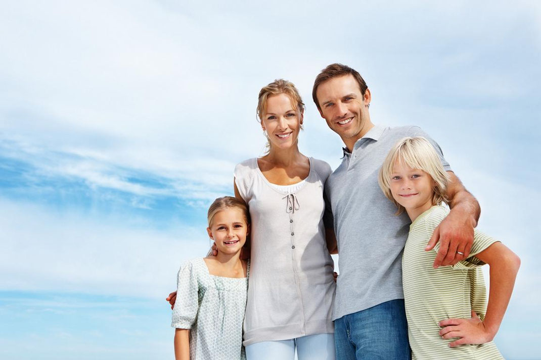 Familie unter blauem Himmel, steht für die finanzielle Absicherung der Angehörigen durch eine Risikolebensversicherung