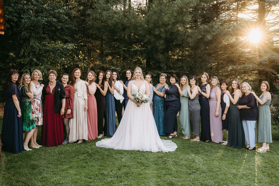 Gruppenfoto: Alle Frauen der Hochzeit in Abendstimmung vor dem Waldhof.