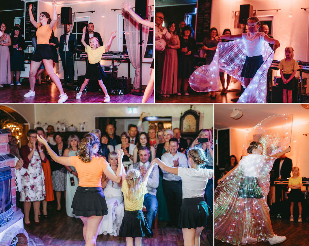 Brautpaar und Gäste tanzen ausgelassen auf der Hochzeitsparty im Erzgebirge, im Hintergrund der DJ mit Lichteffekten, fotografiert von Lichtecht Hochzeitsfotografie."