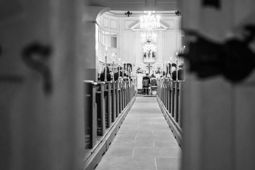 Perspektive vom Mittelgang: Der feierliche Segen in der voll besetzten Kirche Dorfchemnitz – ein Highlight der Hochzeitsreportage.