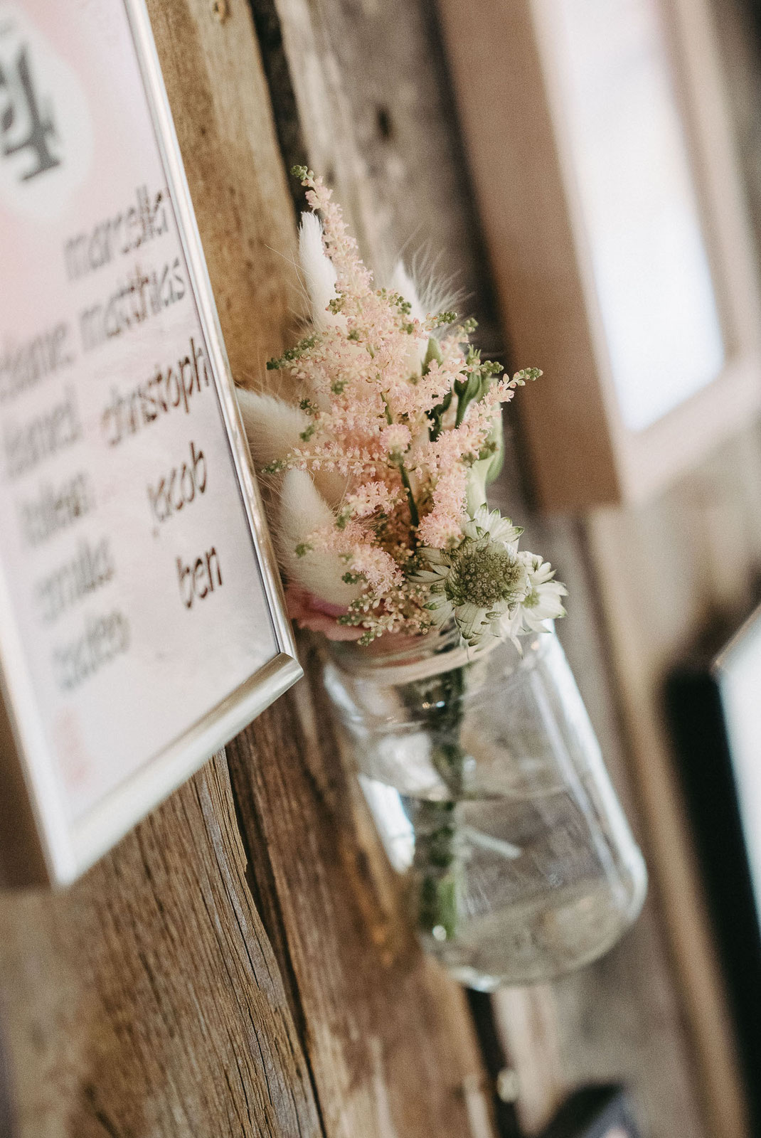 Rustikale Tischdekoration mit Holzelementen und zarten Blumenarrangements im historischen Ambiente.