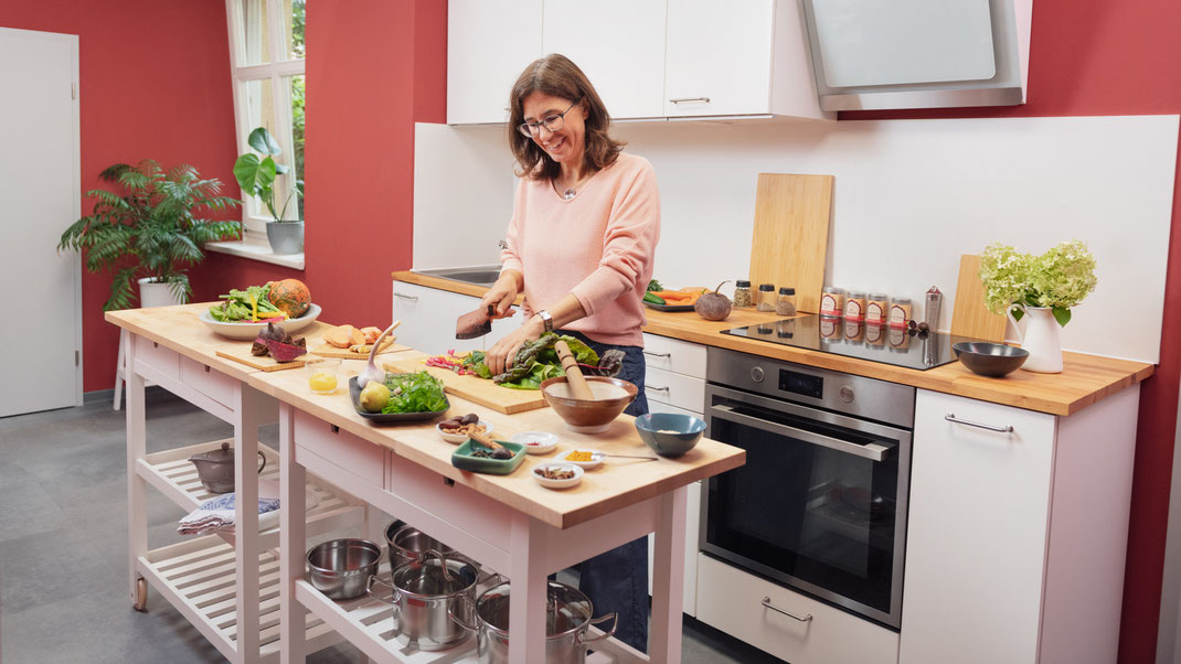 Stephanie Leßmann schneidet Gemüse in ihrem Ayurveda Kochstudio in Weimar für den nächsten Ayurveda Koch-Workshop