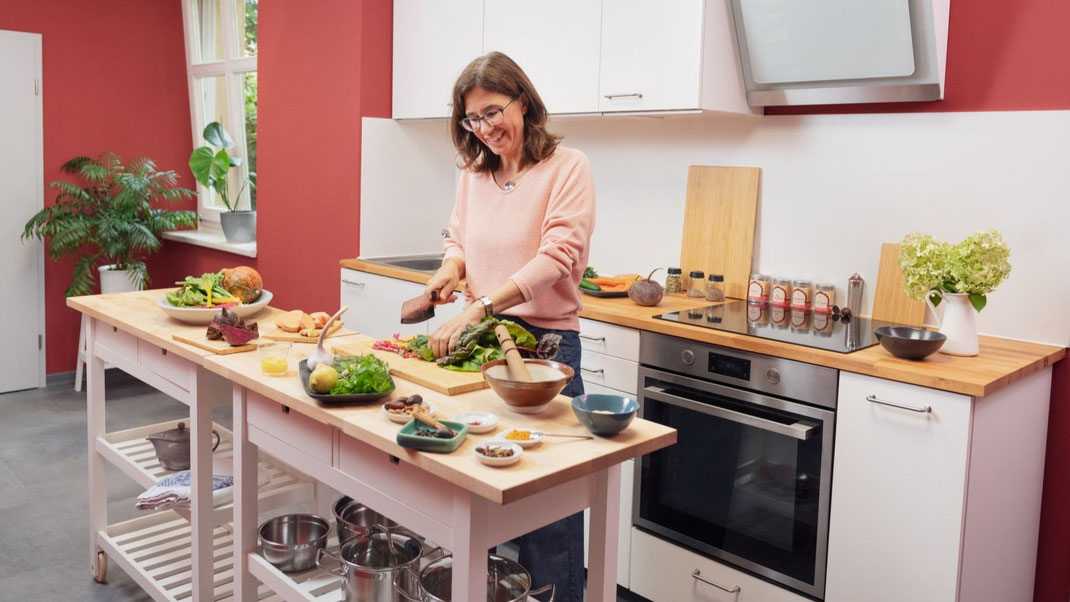 Stephanie Leßmann schneidet Gemüse in ihrem Ayurveda Kochstudio in Weimar für den nächsten Ayurveda Koch-Workshop