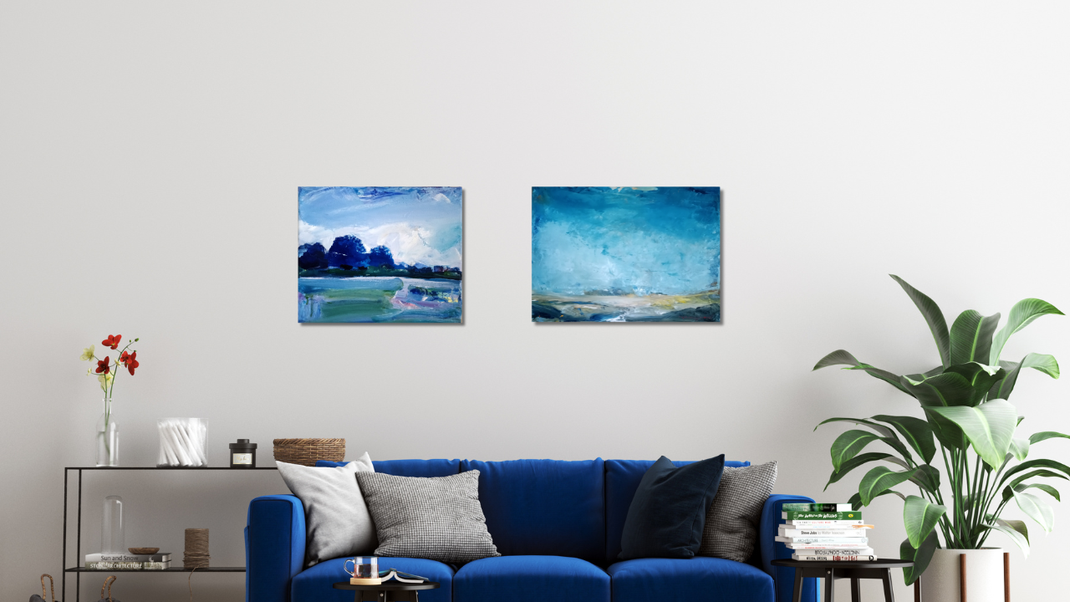 2 Landschaftsbilder in einem Raum mit blauem sofa