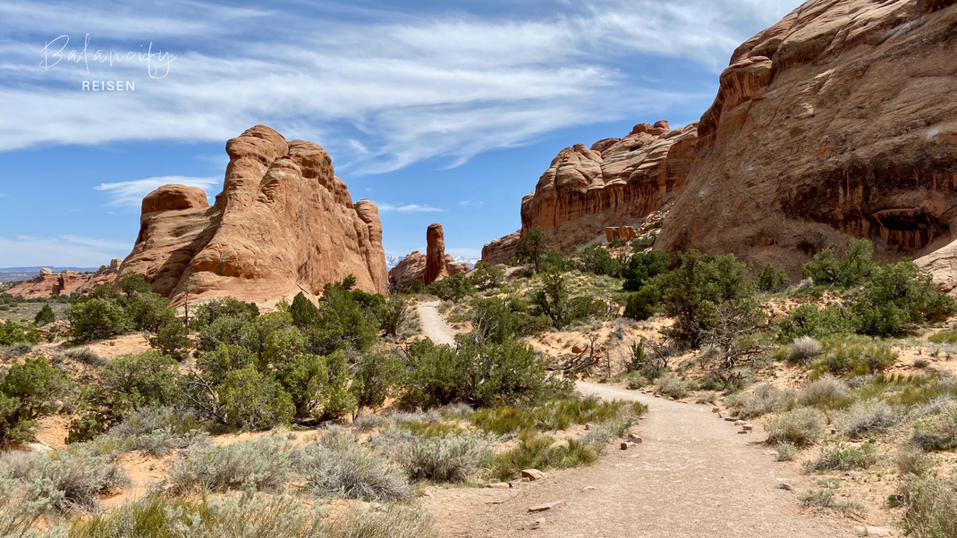 Wanderweg im Arches Nationalpark mit roten Felsen und weitem Blick über die Sandsteinlandschaft