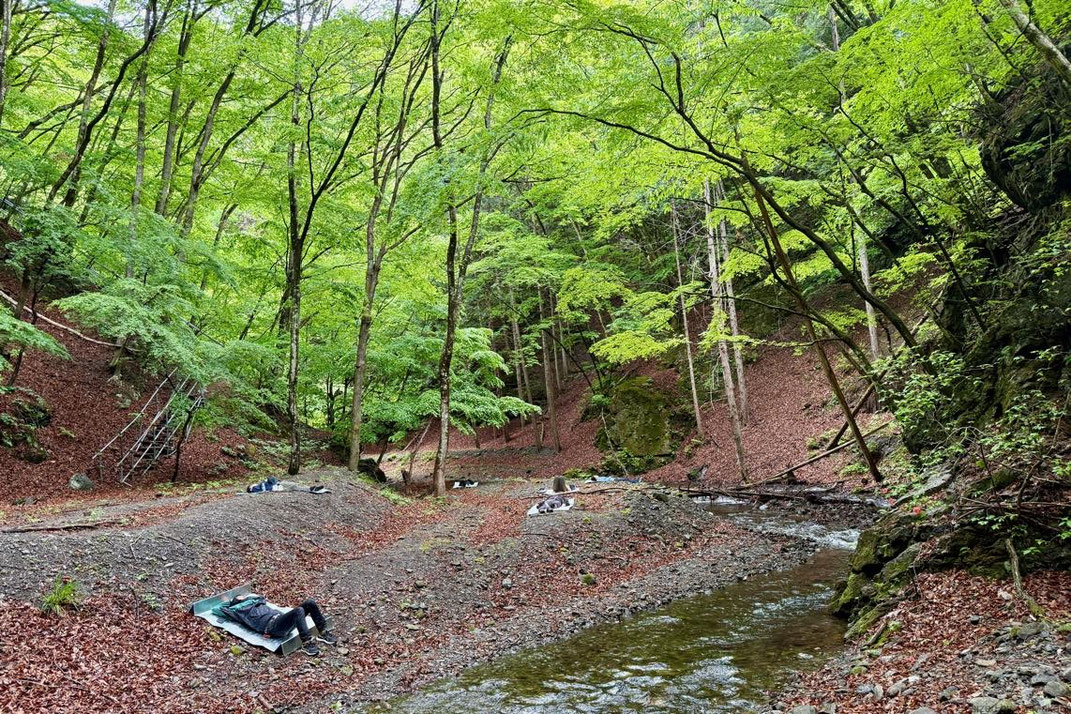 森を流れる沢のほとりで、寝転んだり座ったりしながら、それぞれが想い想いに過ごす時間