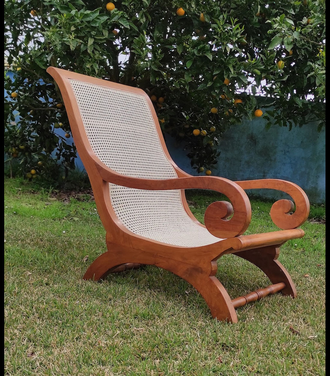 Reparación de asiento de silla con rejilla natural tejida a mano. Proceso de restauración de silla antigua con rejilla nueva. Cambio de rejilla dañada en silla clásica de madera. Artesano tensando rejilla natural en asiento de silla.