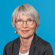 Portrait von Andrea Bürki vor blauem Hintergrund