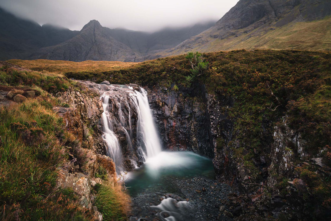 Der Wasserfall Fairy Pools auf der Isle of Skye in Schottland vor einer Landschaftskulisse bei bedecktem Himmel