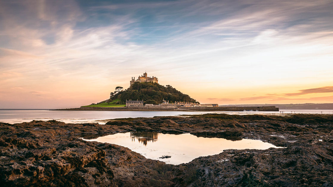 Der St Michaels Mount in Cornwall spiegelt sich in einer Pfütze bei Sonnenuntergang