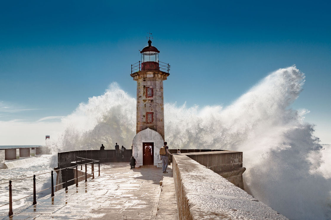 Der Leuchtturm Farol de Felgueiras in Porto in Portugal mit hoch aufschäumender Gischt der Brandung (Architekturfotograf)
