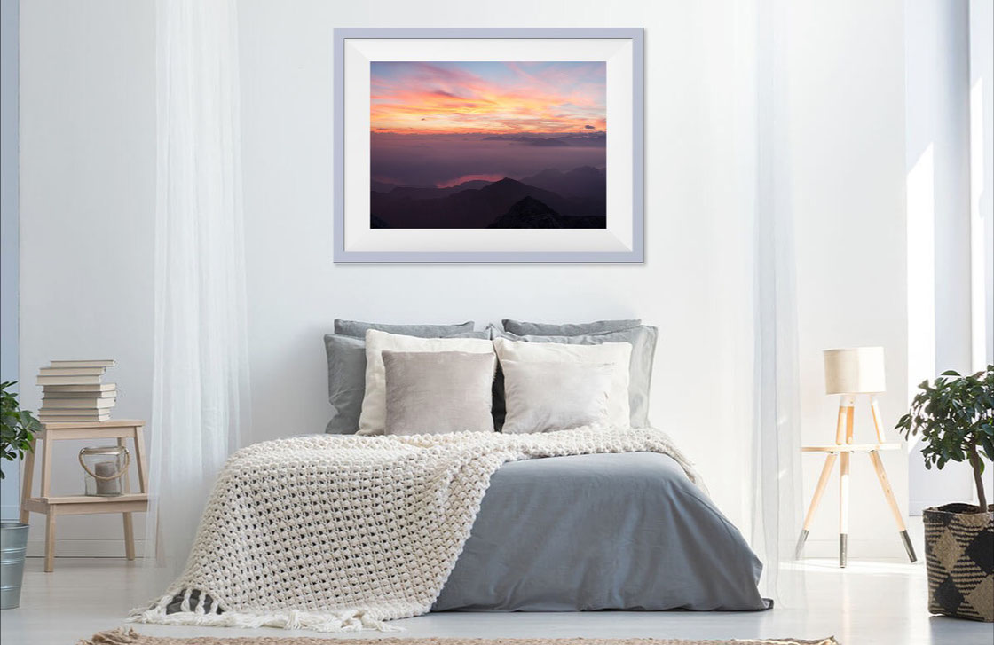 Photo of a bedroom with a fine art print of the sunset over Lake Como and the Alps seen from Grigna.