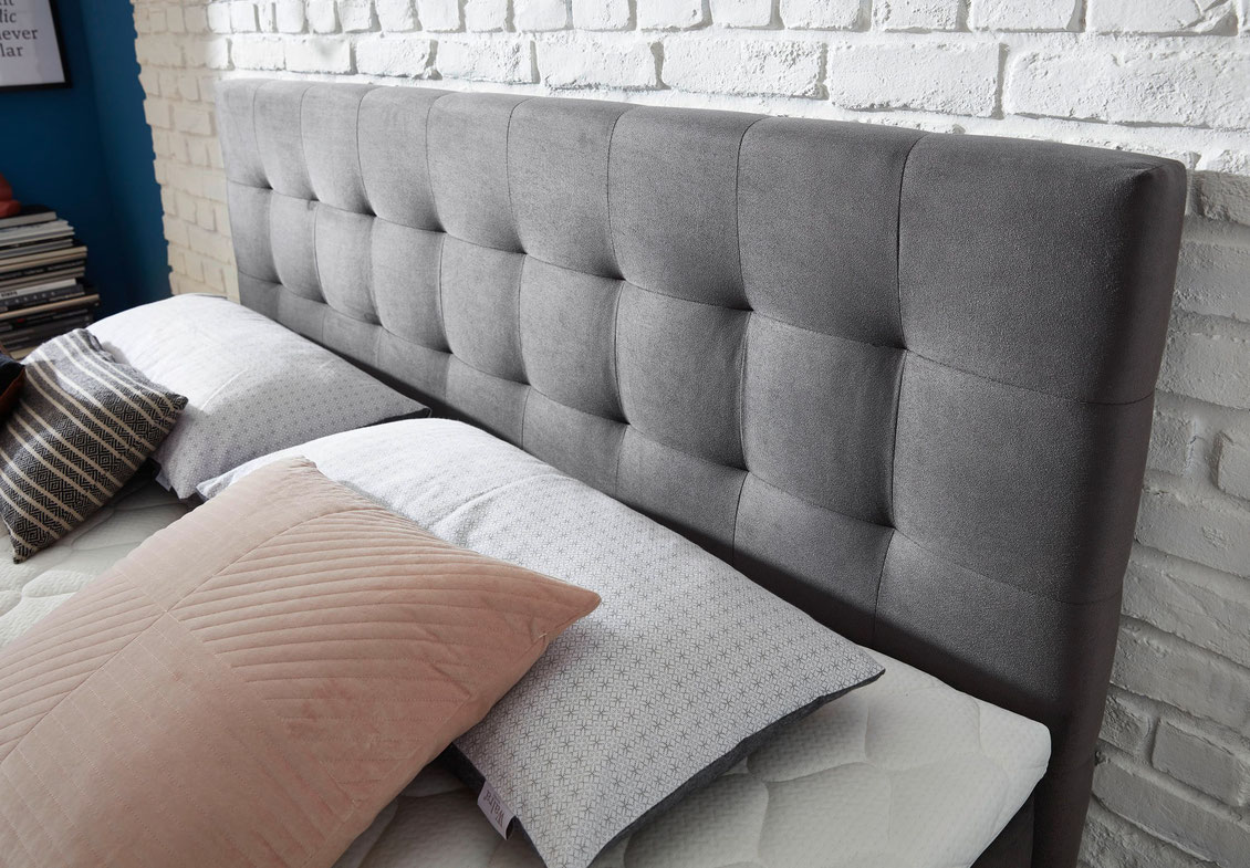 Boxspring bed with quilted headboard in grey velvet