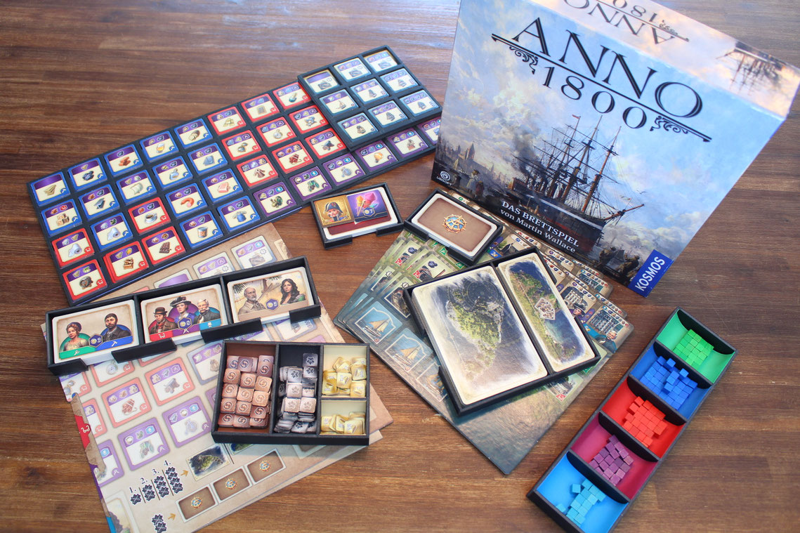 Intelligentes Insert für Anno 1800 mit Mulden im Inlay für die Steine und Plättchenrahmen. Der Organizer liegt mit Spielmaterial auf einem Tisch.