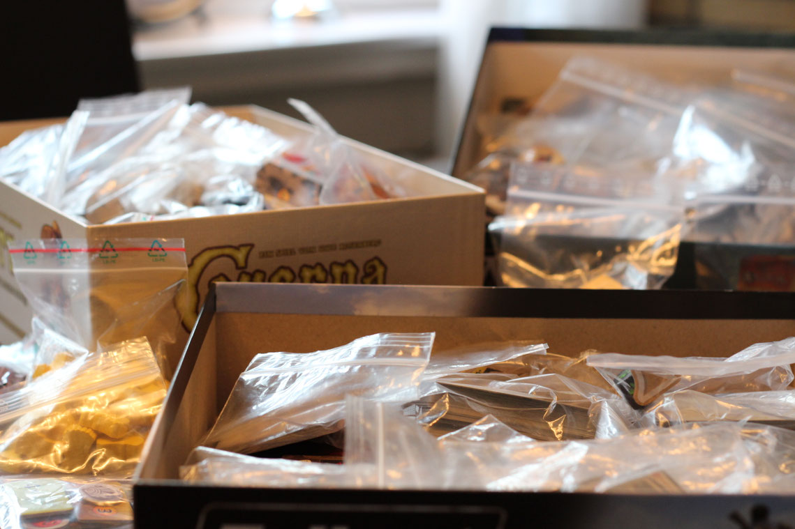 Offene Boxen unordentlich mit Spielmaterial in Tüten und Tütchen verpackt