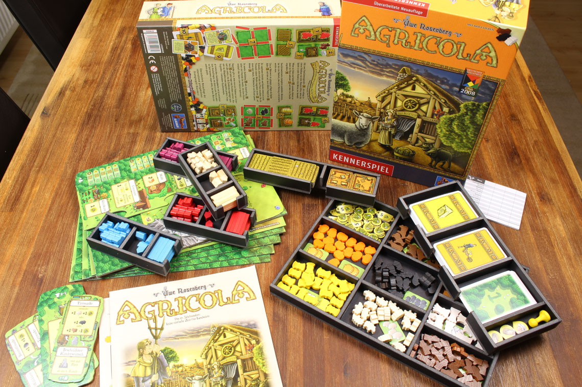 Brettspiel Agricola ausgebreitet im Insert auf einem Tisch. Der Organizer oder das Inlay ist mit Spielmaterial befüllt.