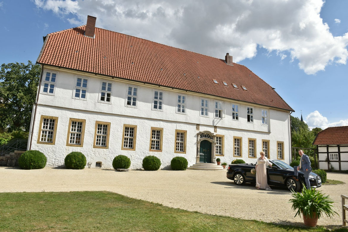 Brautpaar im Traumgarten vor historischem Gebäude