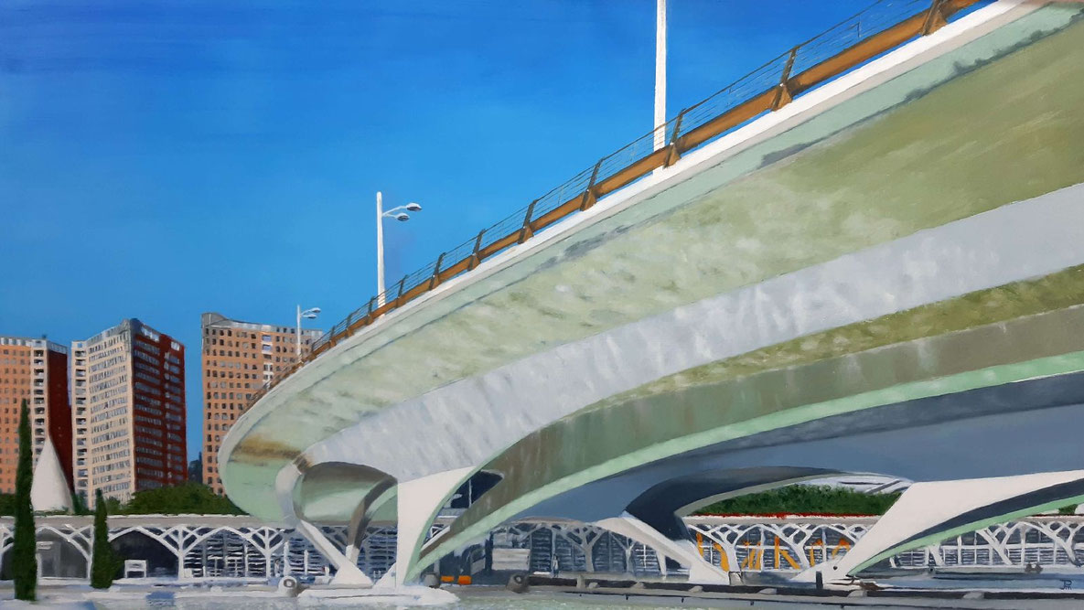 Puente de Monteolivete con estructura curva blanca, reflejos en los lagos y edificios urbanos al fondo en un día soleado.
