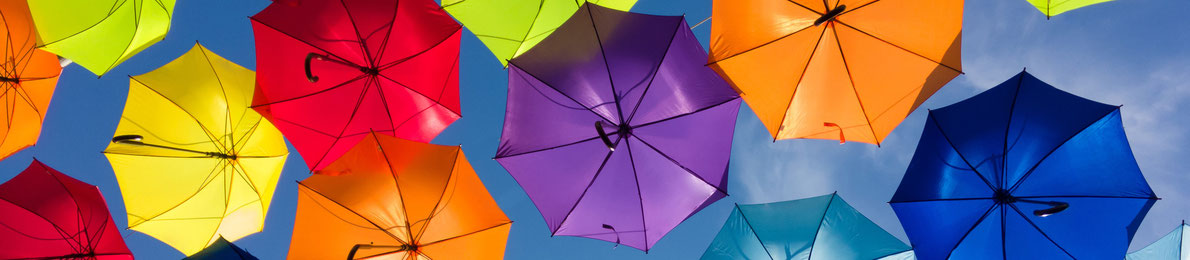 bunte Regenschirme vor einem Wolkenhintergrund
