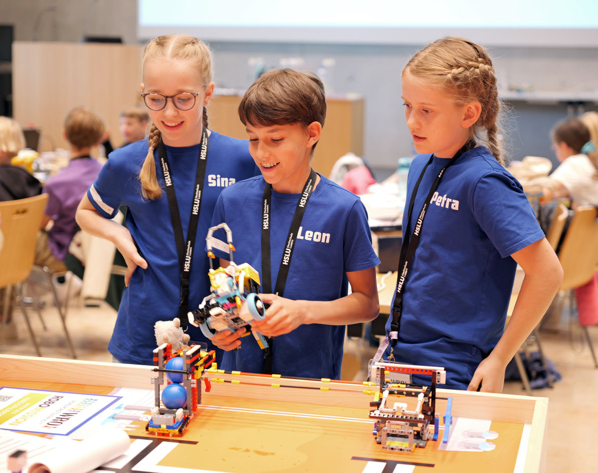 Sina Heller, Leon Wüest und Petra Vonwyl vom Robo-Team WVH aus Ettiswil beobachten gespannt, ob ihr Roboter die Aufgabe wie geplant ausführt. (Bild: HSLU)