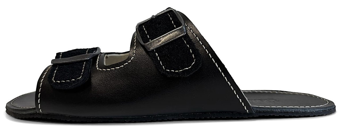 Handgefertigte Pantolette aus schwarzem gegerbten Leder mit Nähten in Weiß. Mit eingestanzten Senmotic Logo. Zwei Riemen verstellbar mit Schnallen aus Metall. Laufsohle 3 mm Kautschuk in Schwarz.