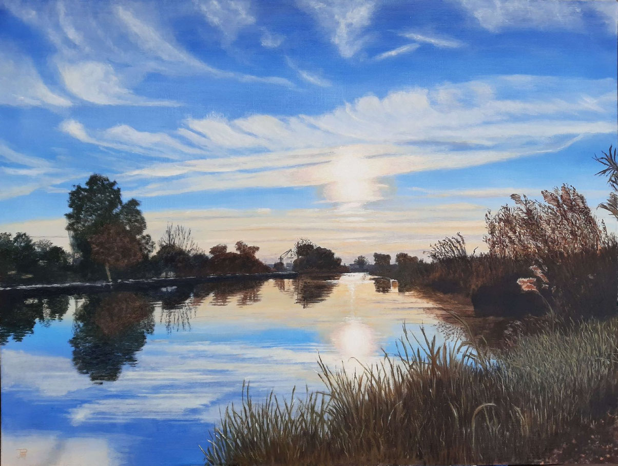 Amanecer en el puerto de Catarroja con reflejos en el agua, vegetación y luz suave sobre el canal.