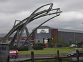 Sentinel sculpture by Tim Tolkien at Spitfitre Island. The Jaguar factory int he background was the Spitfire factory. 