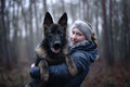 deutscher Schäferhund auf dem Arm von Frau