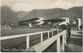 "L'Ippodromo dei Milioni" (heute: Pferderennplatz Meran), eröffnet 1935 mit dreigeschoßiger Stahlbetontribüne in Untermais-Meran, Prov. Trient (heute Auton. Provinz Südtirol). Gelatinesilberabzug 9 x 14 cm; Impressum: Ed. Sciliare, Bolzano 1945.  Inv.-Nr.