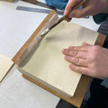 Das Einkleistern des alten Packpapiers zum Verkleben mit dem neuen Vorsatzpapier