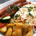 Currywurst mit fruchtiger Tomatensoße dazu Kartoffelecken und Salat 