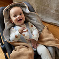 Baby in Babyschale mit Einschlagdecke