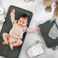 Baby strampelnd auf Wickelunterlage