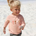Baby mit Schwimmwindel von LÄSSIG am Meeresstrand  