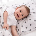 Baby im Kinderbett mit Kinderbettwäsche
