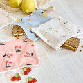 Snack Bag Cherry & Lemon von LÄSSIGauf Tisch mit Korb voller Zitronen