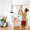 Mama hebt Baby in der Küche hoch