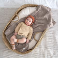Baby im Babykorb liegend