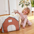 Kind spielend mit Kuscheltier und Activity-Haus