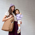 Mutter mit Kind auf dem Arm und Wickeltasche