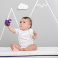 Baby spielt mit Greifling auf Träumeland Matratze