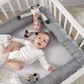 Baby im Kinderbett mit Umrabdung der Bettschlange