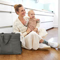 Mutter sitzend mit Baby und Windeltasche