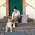 Mutter mit Rolltop und Baby auf Treppe