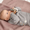 Baby mit Greifringen auf Schmusedecke