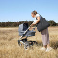 Mama mit Kinderwagen und Wickeltasche in der Lüneburger Heide